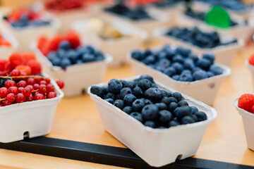 Blueberries and raspberries in box containers at a farmers market