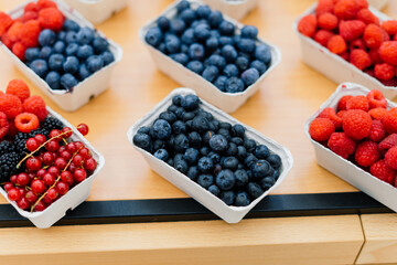 Blueberries and raspberries in box containers at a farmers market