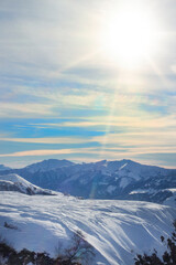 View of the snowy mountain range, Georgia. Landscape. High mountains under snow on a sunny day. Panorama of the white mountains in the snow with a beautiful sky