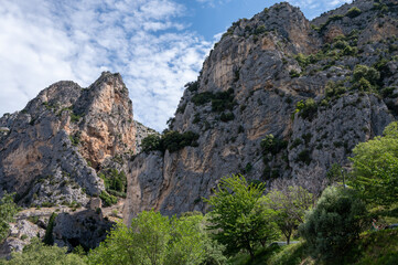 View on mountains cliff, old houses, green valley in remote medieval village Moustiers-Sainte-Marie...