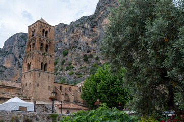 View on mountains cliff, old houses, green valley in remote medieval village Moustiers-Sainte-Marie in Provence, France