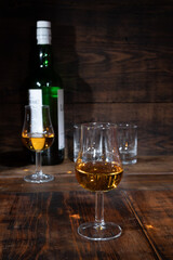 Glasses of strong scotch single malt whisky served on dark wooden table in old pub