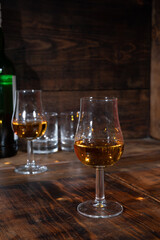 Glasses of strong scotch single malt whisky served on dark wooden table in old pub