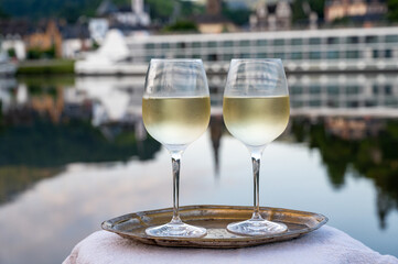 Tasting of white quality riesling wine served on outdoor terrace in Mosel wine region with Mosel...
