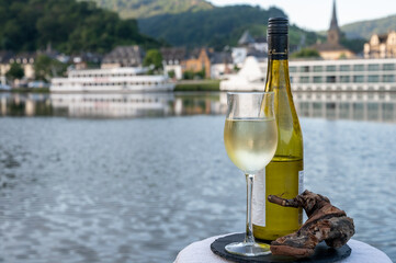 Tasting of white quality riesling wine served on outdoor terrace in Mosel wine region with Mosel...