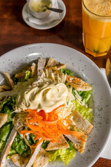 salad lettuce carrot mayonnaise croton on wood and orange juice