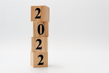 2022 written on wooden blocks in vertical direction isolated on white background with copy space