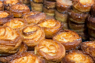Kouign amann pastries stacked at a bakery.  These desserts are the most buttery, calorie dense and...