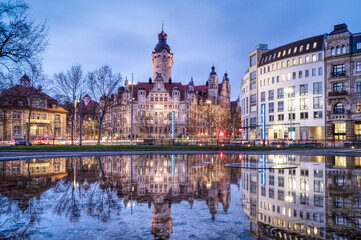 Cityscape of Leipzig (Germany) with the New Town Hall, seat of the city administration since 1905, reflecting at the blue hour in the water of a fountain.