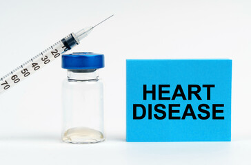 On the table is a syringe, an injection and a blue sign with the inscription - HEART DISEASE