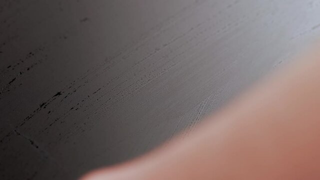 caucasian hand wiping wet black digital screen surface with bare hand