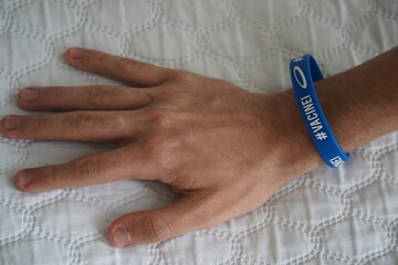 Student, 15 years old, shows his hand with bracelet that has the inscription VACINEI (Vaccinated)....