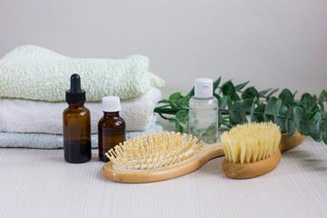 Composition with hair care products, towel and brush on wooden table