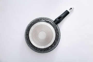 Back view of black marble frying pan on light grey background, top view