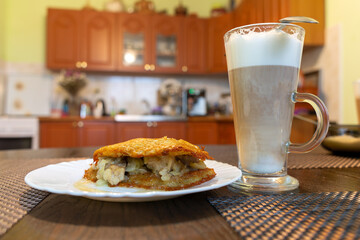 Delicious breakfast, coffee with milk and potato pancakes with meat.
