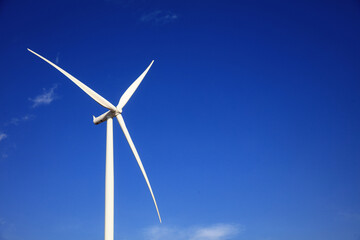 Wind Turbine generate electrical power, Green energy and environment concpet,  huge white wind turbine aginst blue sky