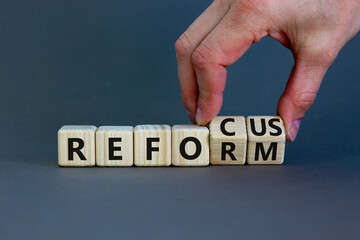 Refocus and reform symbol. Businessman turns cubes and changes the word refocus to reform....