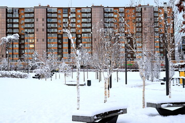 Winter street, park, high-rise building, skyscraper. Winter city snow landscape, background. Ukraine, Dnipro, Dnepropetrovsk
