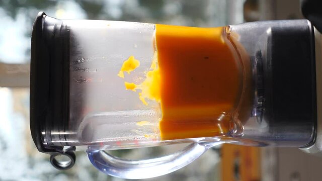 Creamy pumpkin soup cooking in blender bowl. healthy food concept. Cooking at home or restaurant. Steam rising up. Vegetable dish. Vertical footage. 4 k video