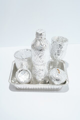 Unique and real still life composition. Food and drink in aluminium foil. Space travel and food...