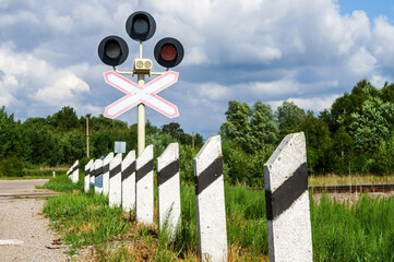 Red traffic light at the railway crossing. Warning sign before the railway crossing. Attention...