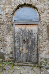 A brown church wood old door with brick wall on the georgian street