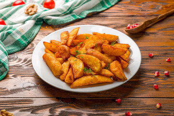 The potatoes wedges on wooden table