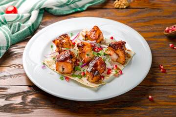 chicken kebab on plate on wooden table side view