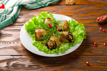 Eggplant rolls stuffed with nuts on wooden table