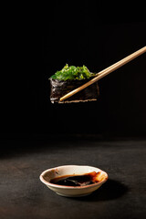 wacame sushi with chopsticks