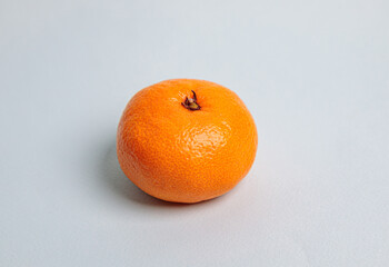 One tangerine on a blue background.