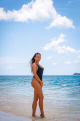 Girl in bikini posing on the sand by the sea. White girl with long hair