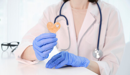 young doctor cardiologist holding heart figure in hands,