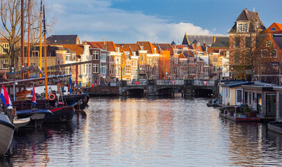 Fototapeta premium Beautiful old houses on the city embankment of Leiden at sunset.