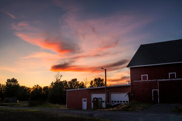 A sunset over a country side barn