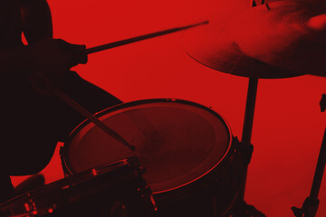 Silhouette close up shot of sticks and drums on a red color background