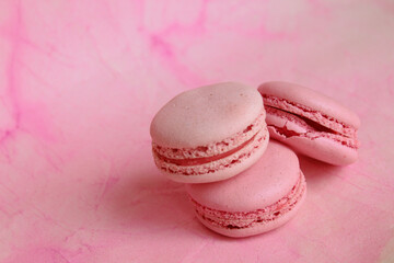 Three pink macaroon cakes on a pink background. Bright pink background.