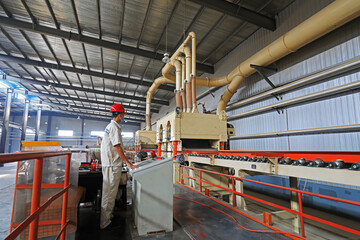 workers work intensively on the wood plate processing production line in the factory, China