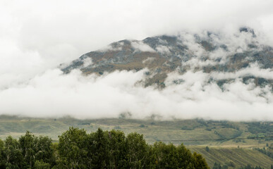Mountain village, wooden houses, mountains, forests, natural scenery, under the background of cloudy weather. In Altay, Xinjiang, China.