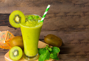 Kiwi yogurt fruit juice smoothie green colorful fruit juice milkshake blend beverage healthy high protein the taste yummy In glass drink episode morning on wood background.