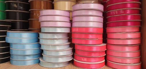 Bright ribbons for decoration and gift wrapping. Many spools of colored ribbons. Beautiful ribbons on the shelf in the store.