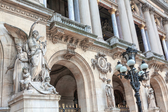 Baroque architecture and sculptures . Facade of Opera Garnier in Paris . Marble statue and columns