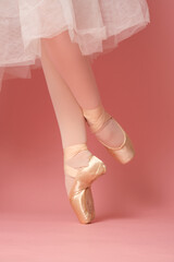 classic ballet dancer feet on tiptoe on pink background