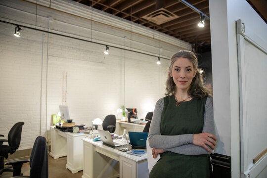 Portrait Of Confident Creative Businesswoman In Open Plan Office