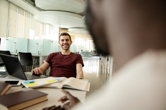 Students Talking In University Library And Smiling