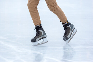 Ice skating on an ice rink. legs with skates. Winter active sport and leisure hobby.