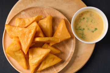 Deep fried Burmese tofu made from flour and chickpeas on black background
