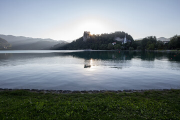 Panorama of the Bled lake, Blejsko Jezero, with its castle, Blejski Hrad, during a sunny sunset in summer with the mountains of Julian alps. Bled Castle is a major monument of Slovenia......