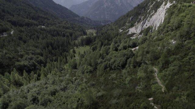 Drone video with descriptive frontal shot over the Vrsc pass in Slovenia with mountains on the horizon.