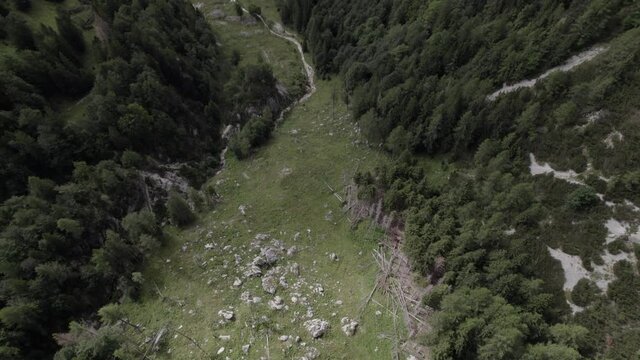 Descriptive back-up back shot drone video over Vrsc pass in Slovenia with mountains on the horizon.